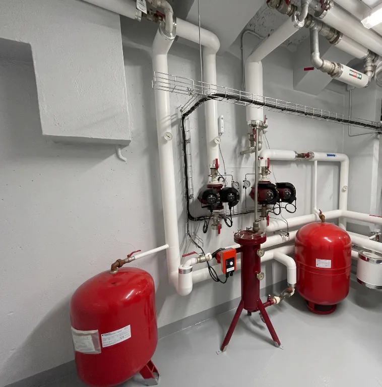 Panoplie hydraulique de chaufferie avec circulateurs doubles, vases d'expansion, vannes et réseaux de chauffage calorifugés.